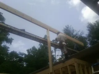 Carpenter setting a ridge beam over a new addition frame — Ice Dam Removal by Roofing Brothers in Bishop Hill