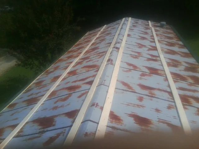 Rusted metal roof panels with new wood purlins before replacement — Storm Damage Roof Repair in Bishop Hill by Roofing Brothers