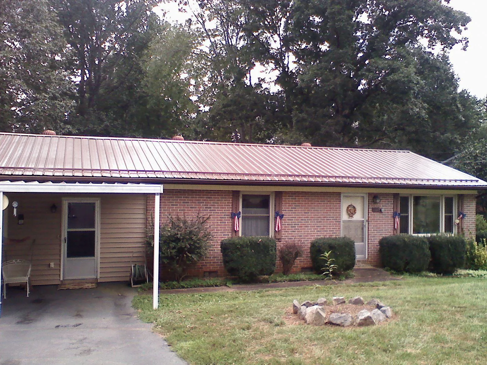 Bronze metal roof and carport on a brick ranch home — Roof Repair work by our crew in Bishop Hill